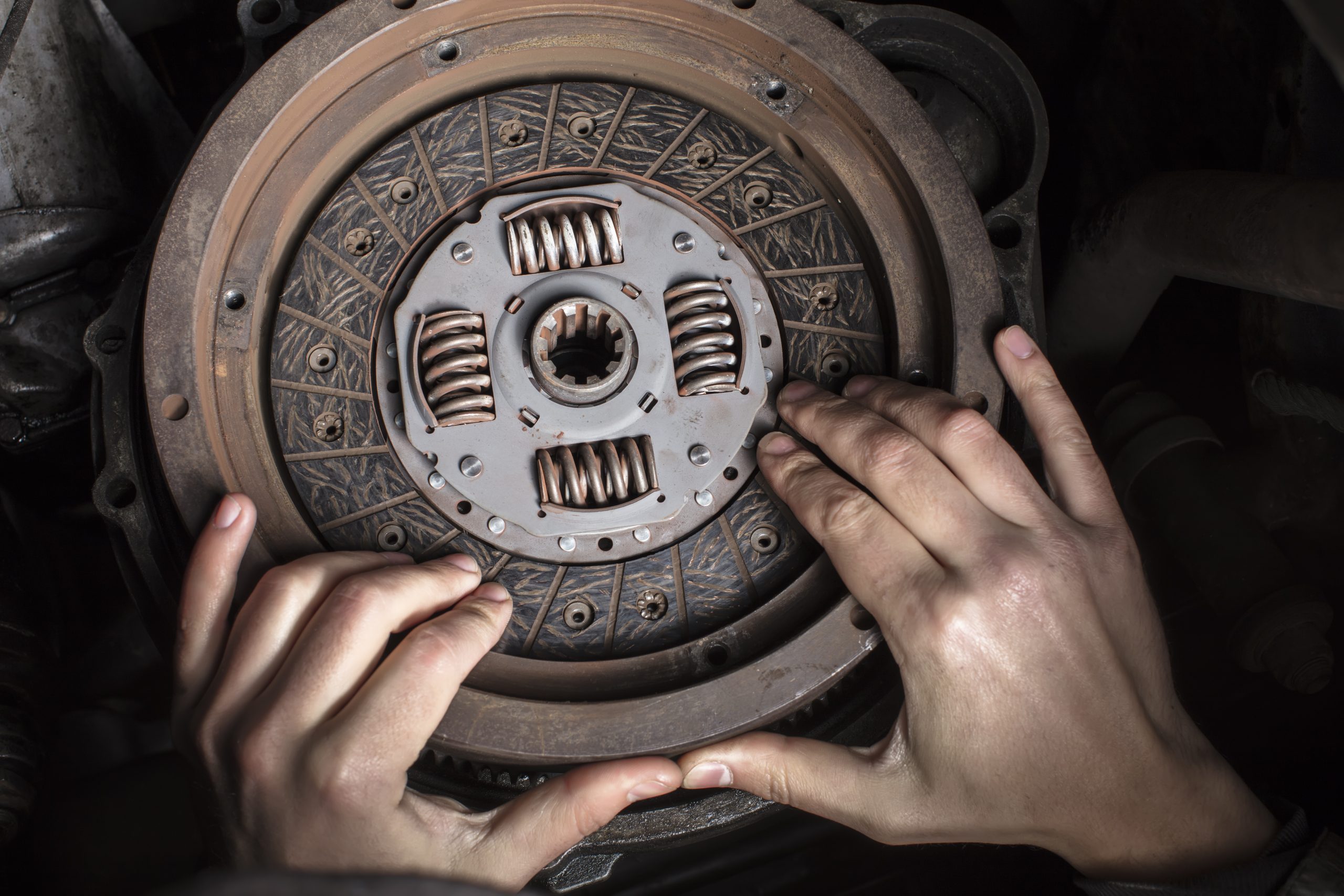 car engine maintenance. engine clutch repair. hands with a mechanic with a clutch disc.