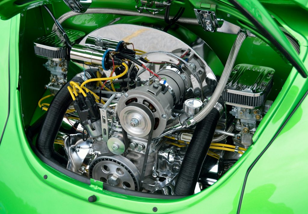 Close-up of a reconditioned car engine with chrome components and green bodywork – engine replacement service in Thanet