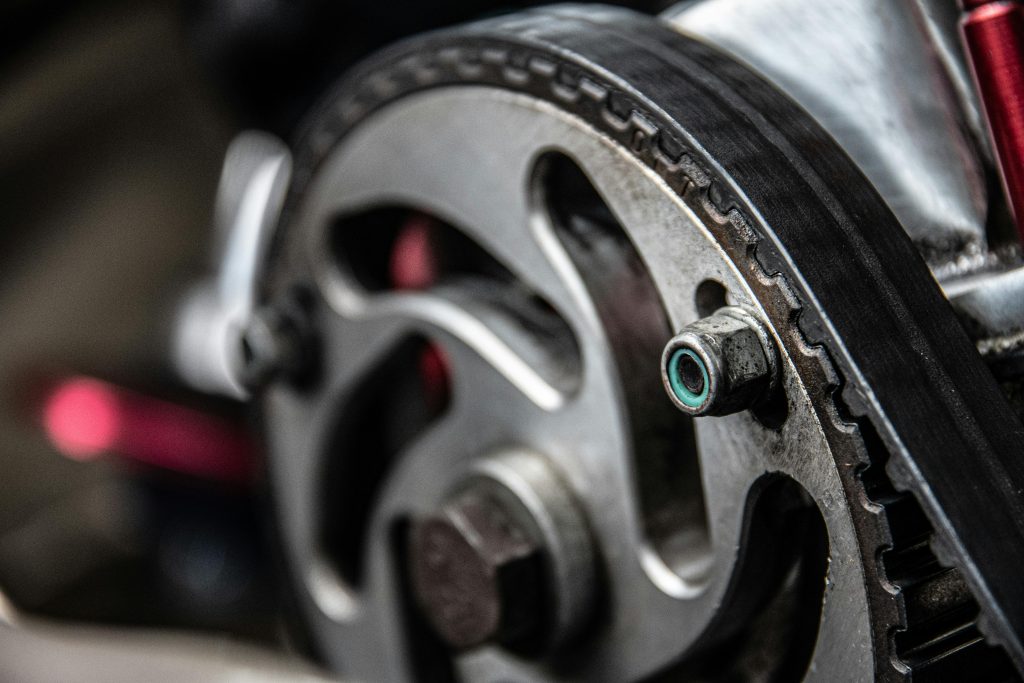 Focused shot of a car engine's metallic timing belt component, essential for maintenance and repair.
